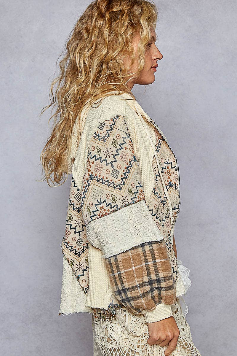 This beige balloon sleeve jacket features a front zipper, textured thermal fabric, and a mix of patterned patches, ideal for Long Island boutique fashion.