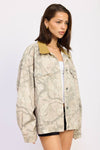Oversized camo trucker jacket in neutral tones features a contrasting mustard collar, perfect for stylish layering in Long Island boutique fashion.