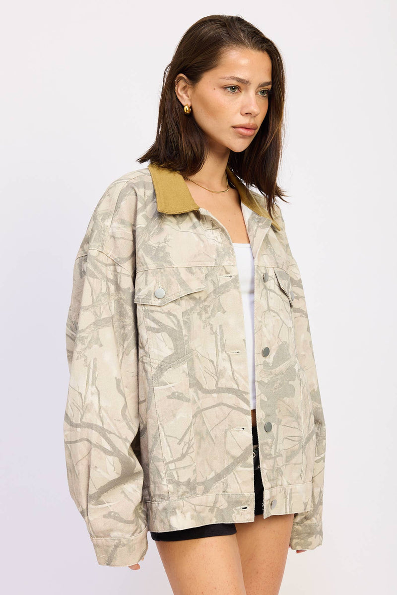 Oversized camo trucker jacket in neutral tones features a contrasting mustard collar, perfect for stylish layering in Long Island boutique fashion.