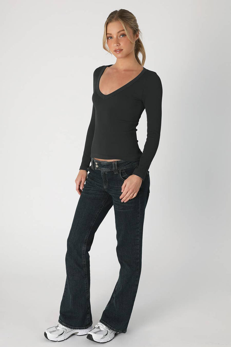 Black deep V neck long sleeve top with a fitted silhouette, paired with flared jeans, perfect for a stylish look in a Long Island boutique fashion setting.