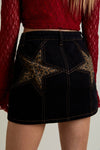 Black denim skirt featuring bold leopard print star patches and contrast stitching, perfect for trendy Long Island boutique fashion.