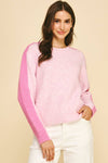 Woman wearing a pink sweater with a beige background