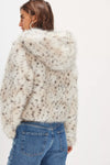 Cozy hooded faux fur jacket in cream with dark spots, featuring a cropped fit, perfect for chic Long Island boutique fashion.
