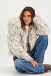 Luxe, hooded faux fur jacket in cream with subtle spotted patterns, perfect for stylish warmth in Long Island boutique fashion.