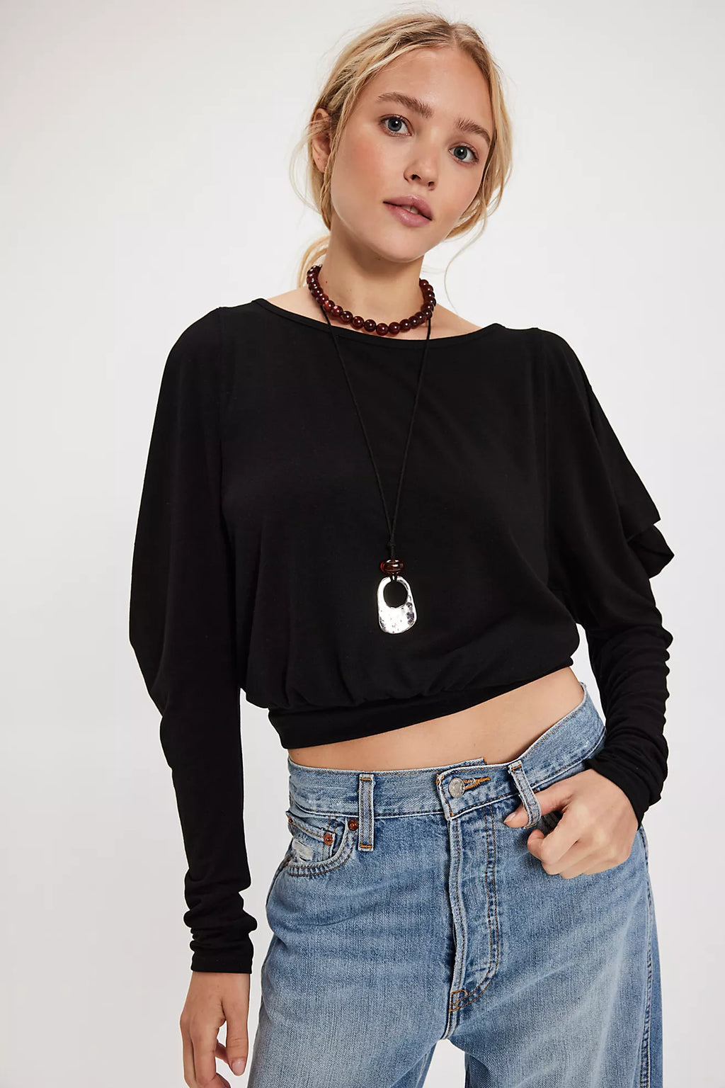 Lightweight black long sleeve top with a cropped fit and draped details, perfect for chic Long Island boutique fashion.