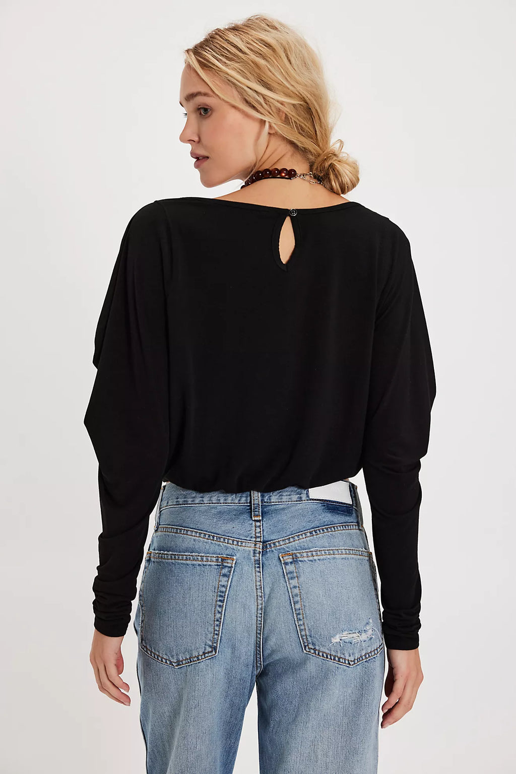 Lightweight black long sleeve top with a cropped fit and draped details, perfect for chic Long Island boutique fashion.