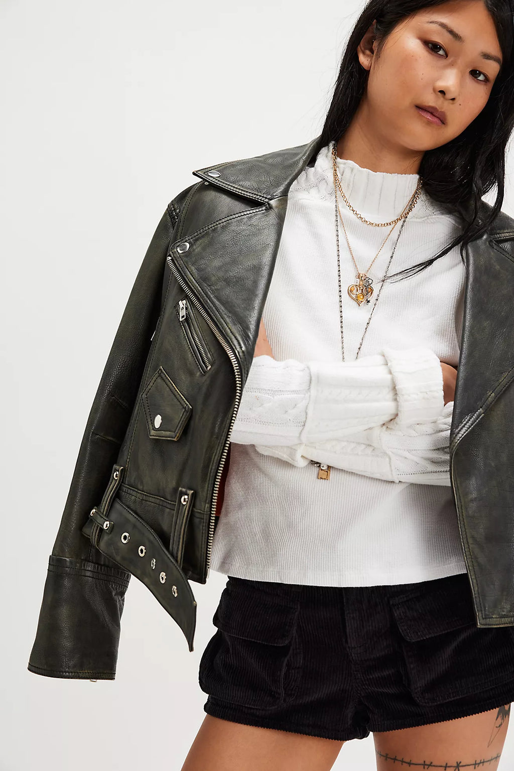Lightweight white ribbed top with a ruffled neckline, styled with a chic black leather jacket and matching corduroy shorts for trendy Long Island boutique fashion.