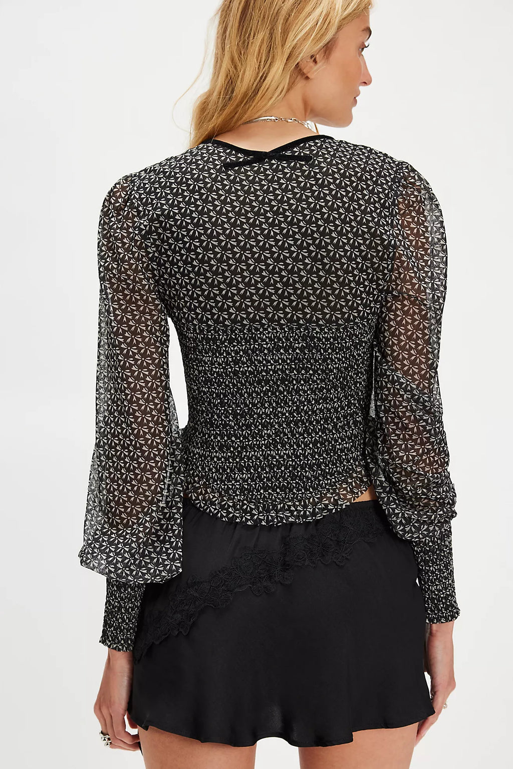 Black Dottie Knit Top featuring sheer fabric, puffed sleeves, and a fitted waist, perfect for layering in Long Island boutique fashion.
