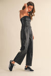 Strapless black faux leather barrel jumpsuit with a tailored fit, featuring a belted waist and wide-leg design, perfect for Long Island boutique fashion.