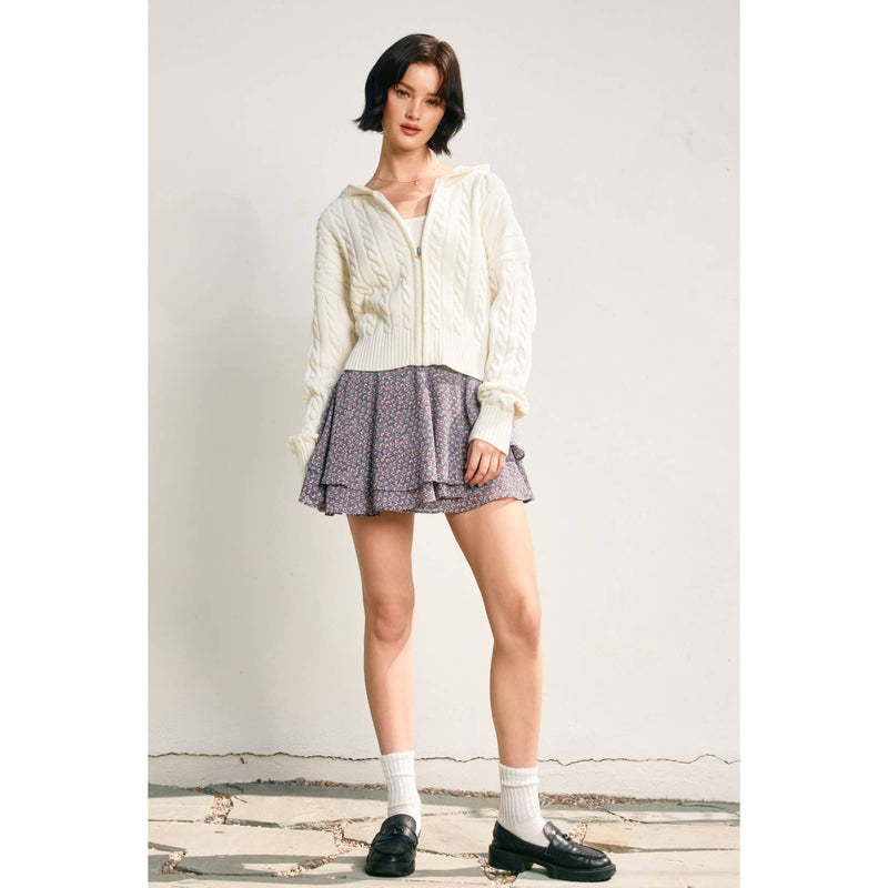 Cozy cream cable knit hooded zip-up cardigan paired with a floral skater skirt, perfect for Long Island boutique fashion.
