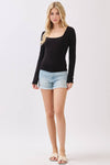 Long sleeve black top with a square neckline and double-layer fabric, paired with distressed denim shorts for a trendy Long Island boutique fashion look.