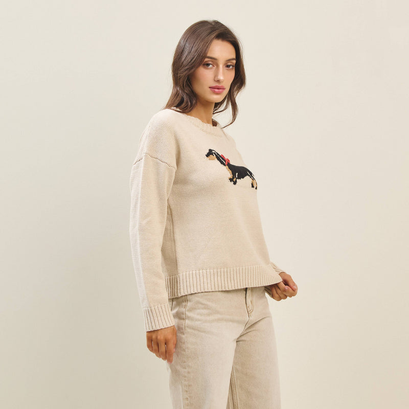 Beige sweater featuring a playful black dachshund with a red bow, perfect for cozy looks at this Long Island women’s boutique.
