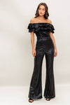 Off-the-shoulder black coated woven jumpsuit with ruffled neckline and flared legs, perfect for a night out in Long Island boutique fashion.