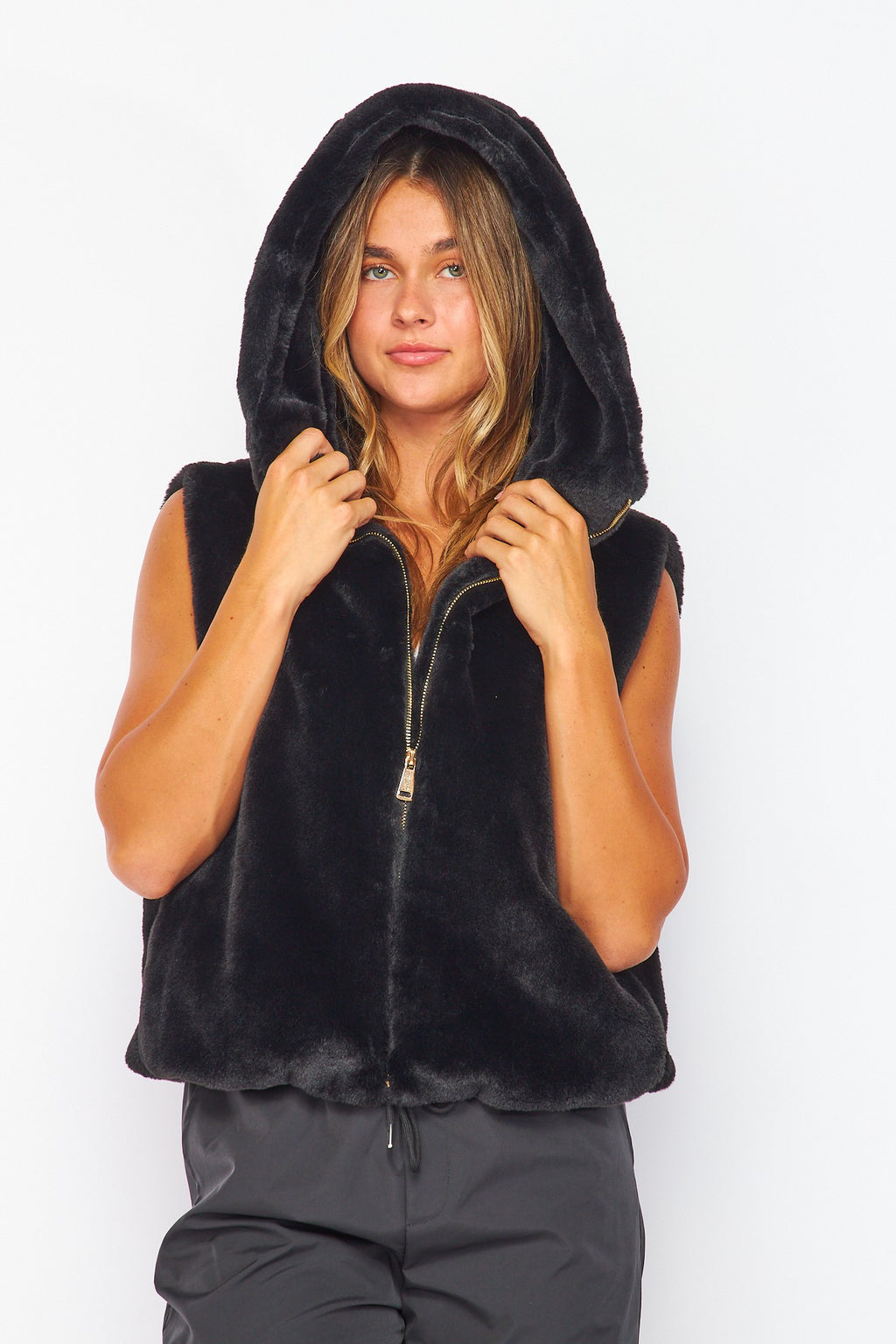Soft black faux fur hooded vest featuring a zip front, stylish pockets, and a relaxed fit, perfect for Long Island boutique fashion.