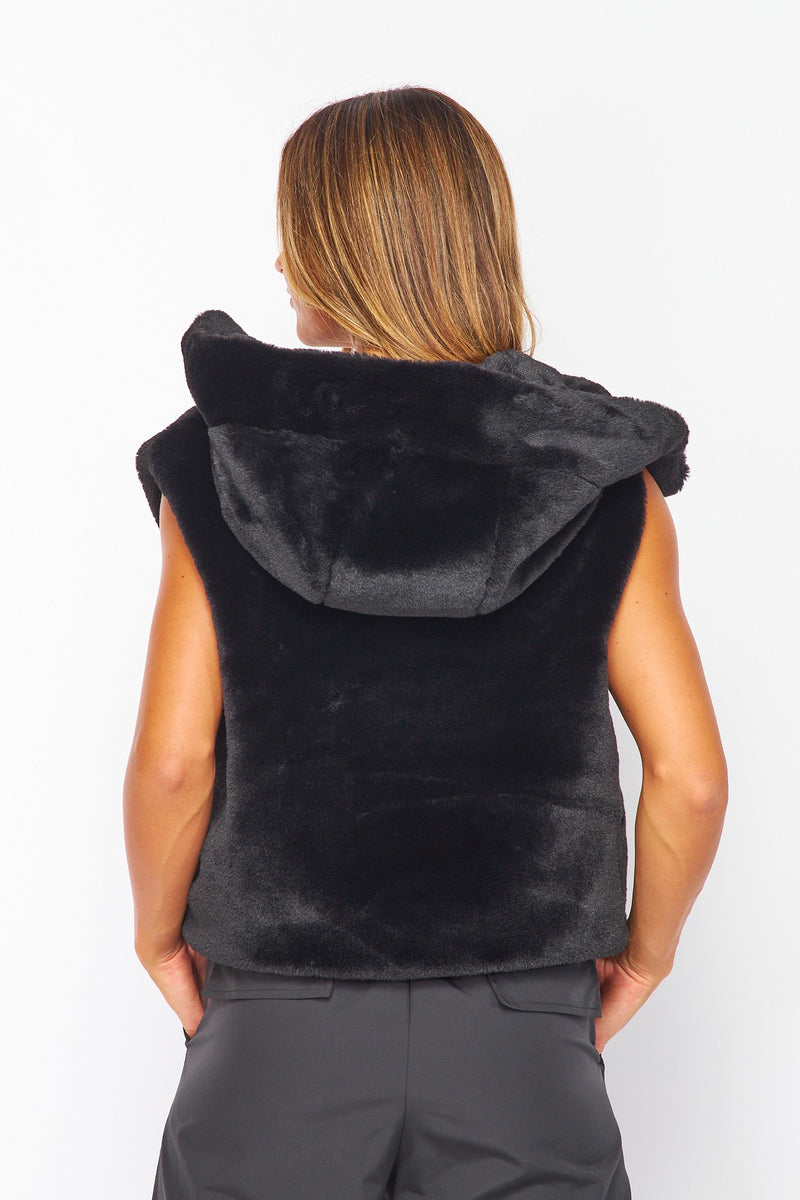 Soft black faux fur hooded vest with a snug fit, ideal for layering in stylish Long Island boutique fashion.