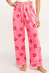 Model wearing pink fuzzy printed pajama pants with cherry print