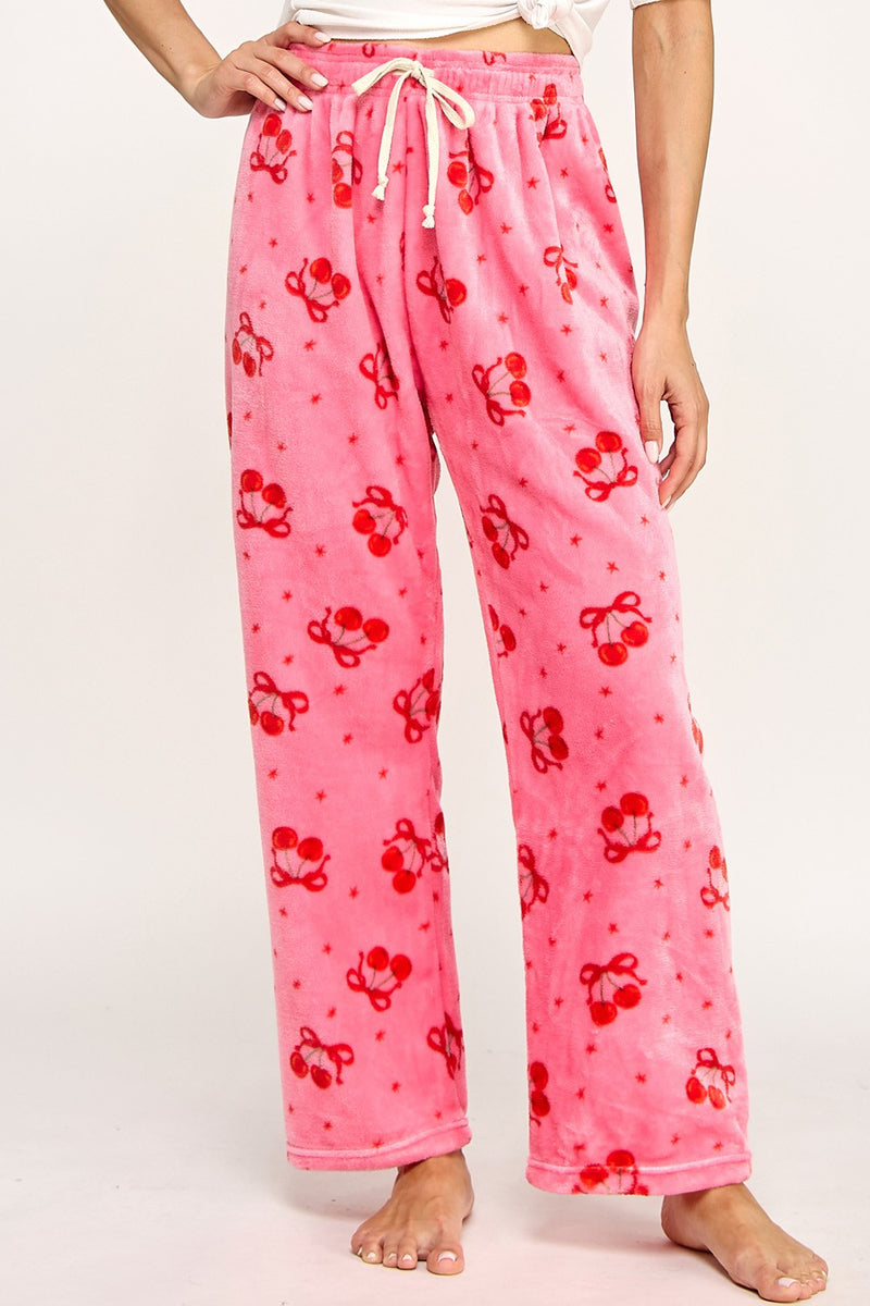 Model wearing pink fuzzy printed pajama pants with cherry print