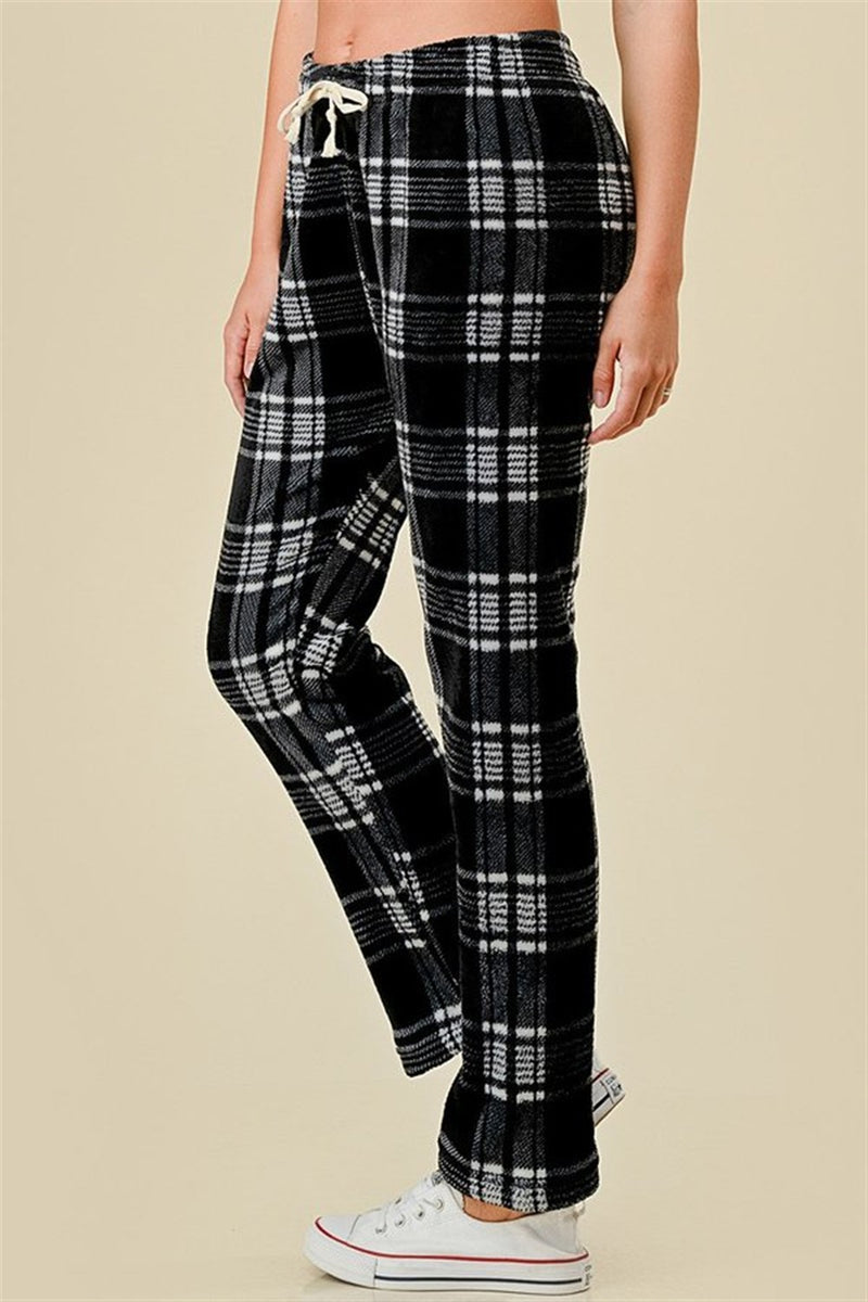 Black and white plaid pants worn by a person on a beige background