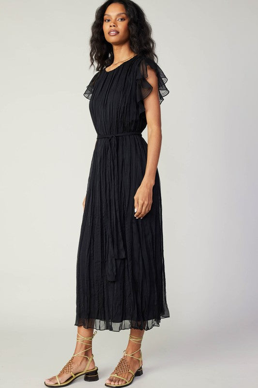 Flowy black Flutter Crinkle Dress features ruffled sleeves and a cinched waist, perfect for a chic Long Island boutique fashion look.