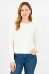 Woman wearing a white sweater and blue jeans on a white background