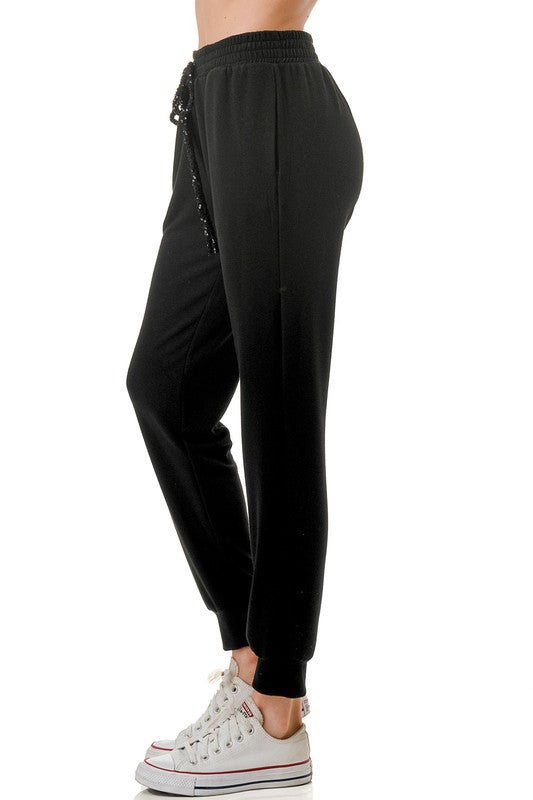 Casual black joggers featuring a comfortable fit, an elastic waistband, and a sequin drawstring, perfect for Long Island boutique fashion.