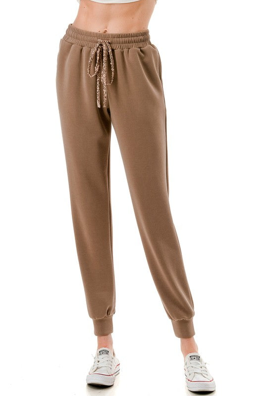 Brown jogger pants featuring a sequin drawstring and elastic cuffs, perfect for cozy styles at this Long Island boutique fashion haven.