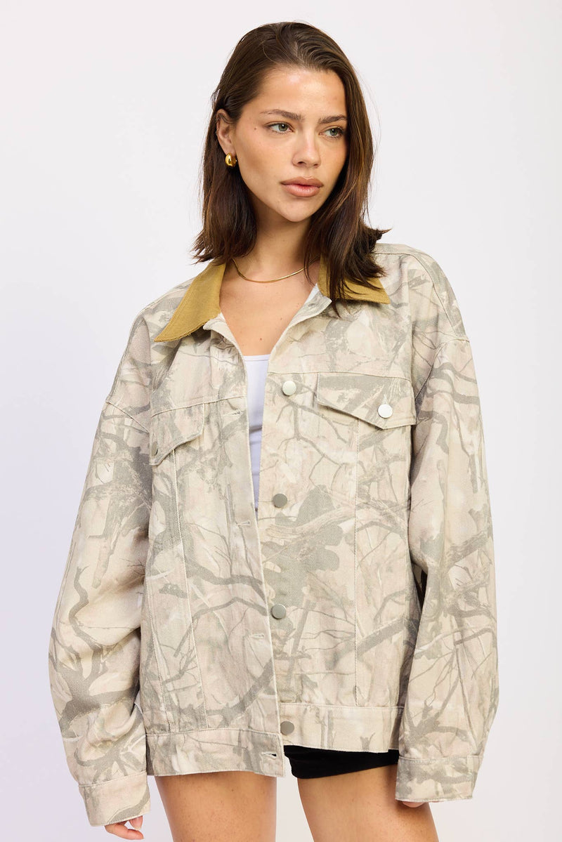 Oversized camo trucker jacket features a neutral-toned pattern and a contrasting yellow collar, perfect for Long Island boutique fashion.