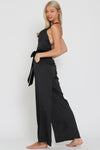 Sleek black sleeveless velvet belted satin jumpsuit with a cowl neckline and wide-leg fit, ideal for effortless Long Island boutique fashion.