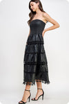 Strapless black eyelet faux leather midi dress with a smocked bodice and tiered design, perfect for Long Island boutique fashion events.
