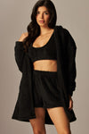 Cozy fleece three-piece pajama set in black features a cropped bra, shorts, and an oversized cardigan for ultimate comfort in Long Island boutique fashion.
