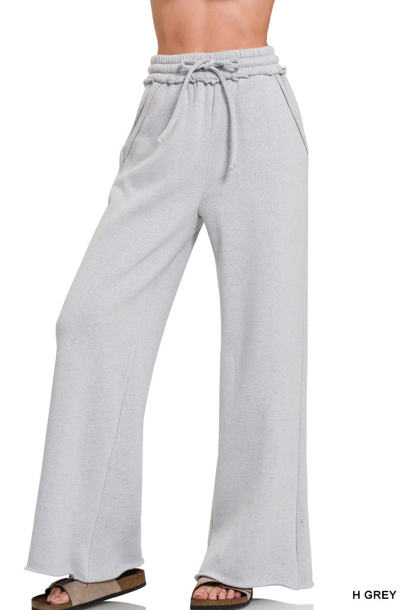 Light grey wide leg sweatpants with exposed seams and an adjustable drawstring waist, perfect for Long Island boutique fashion.