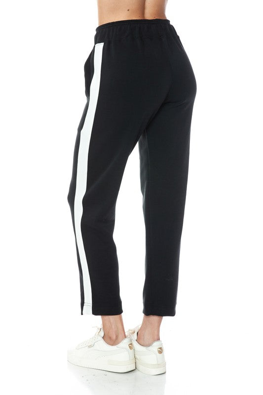 Two-tone straight leg pants in black with white side stripes, featuring an elastic waistband, ideal for chic comfort in Long Island boutique fashion.