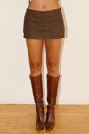 Khaki contrast stitch mini skort with a fitted silhouette, paired with stylish brown knee-high boots, perfect for Long Island boutique fashion.