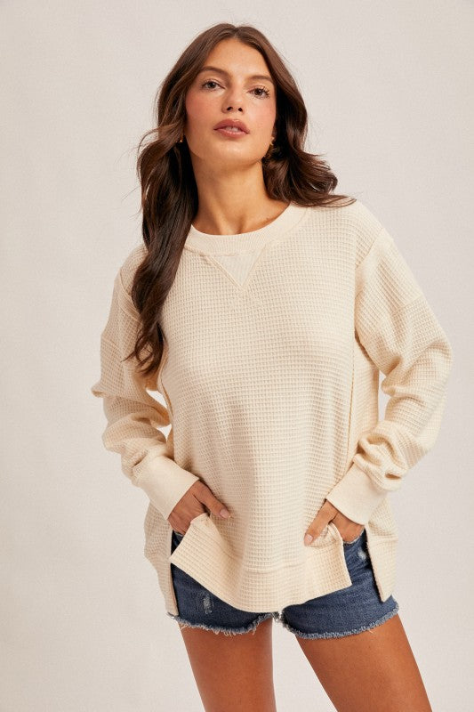 Cream oversized pullover with a brushed thermal texture, featuring a crew neck and side slits, perfect for Long Island boutique fashion.
