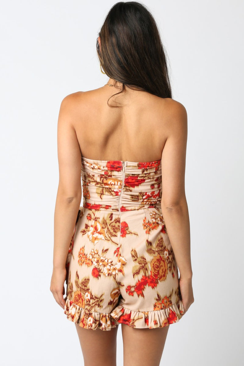 Strapless floral romper featuring earthy tones and a ruffled hem, perfect for warm days in Long Island boutique fashion.