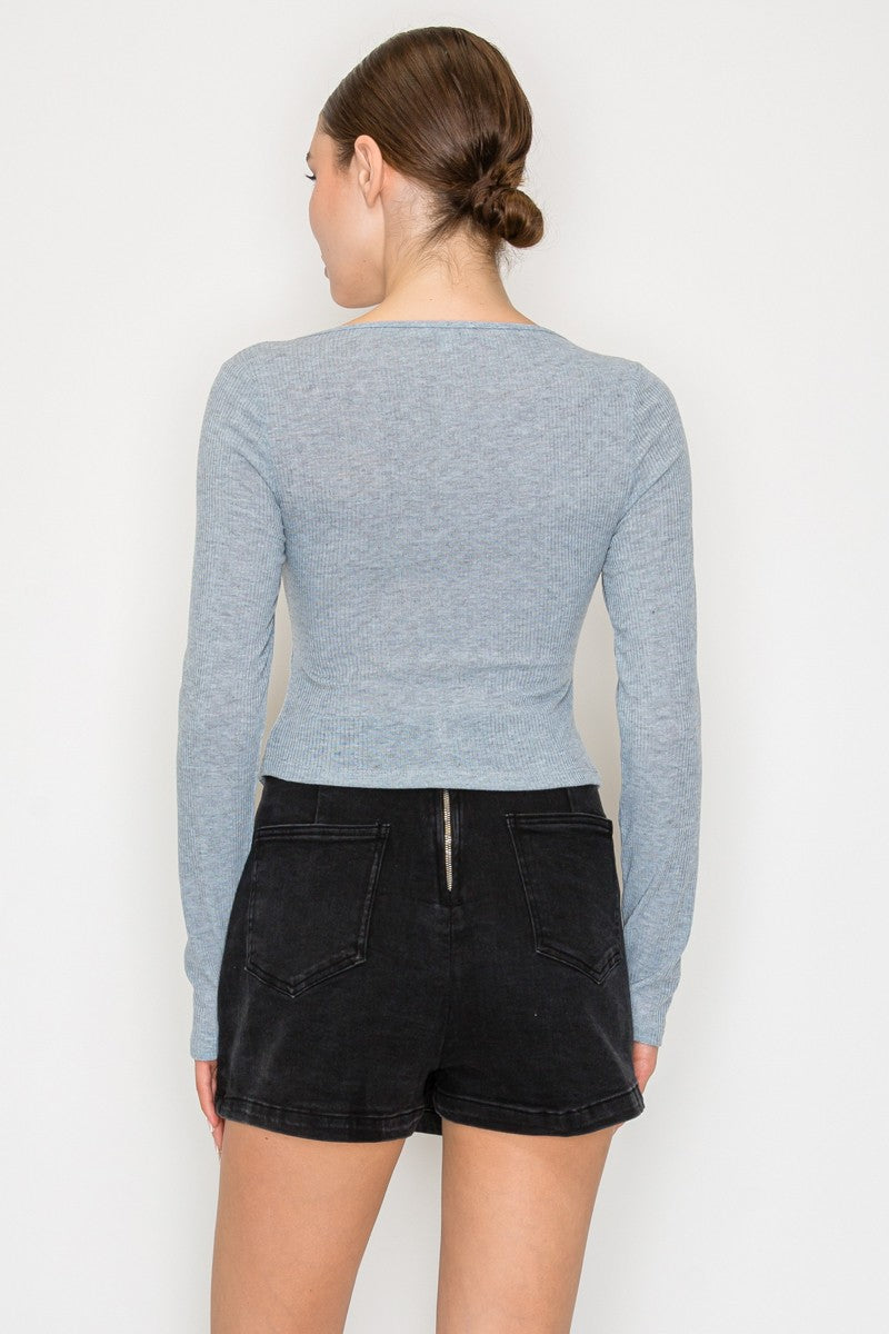 Soft blue half button long sleeve crop top with a fitted silhouette, perfect for pairing with shorts in Long Island boutique fashion.