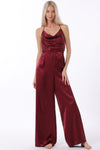 Backless cowl neck jumpsuit in rich burgundy satin with wide-leg fit, perfect for chic evenings in Long Island boutique fashion.