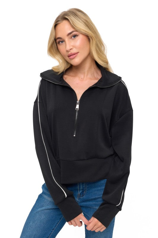 Chic black scuba top with a zippered neckline and white piping, perfect for casual wear at a Long Island women's boutique.