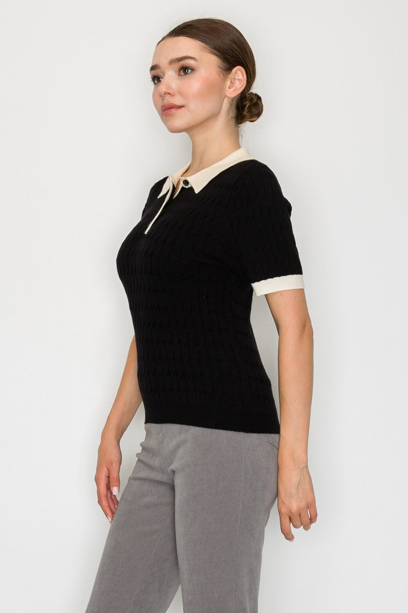 Short-sleeve black collar sweater top with cream trim and button detail, perfect for a chic style in Long Island boutique fashion.