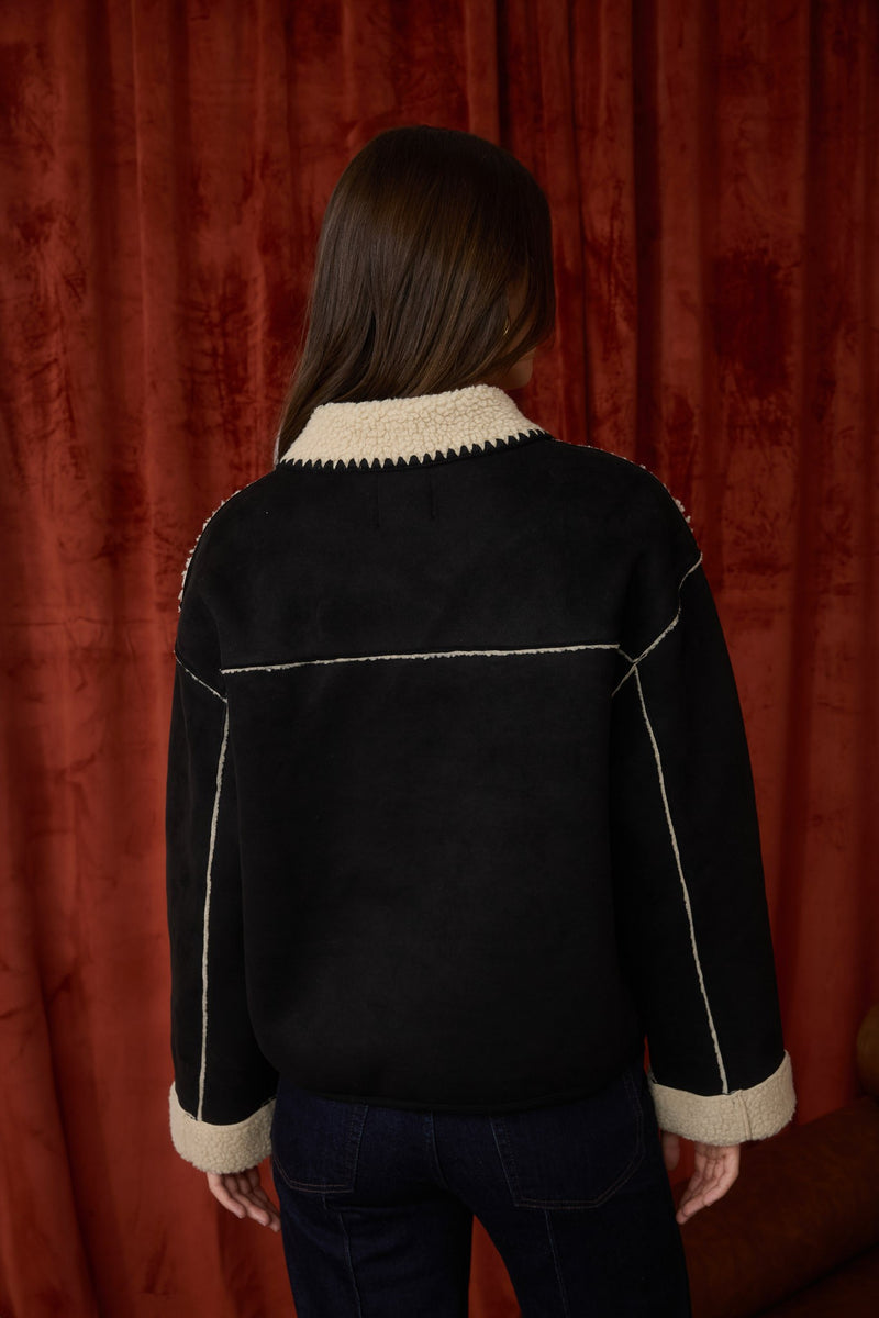 Cozy black faux shearling suede toggle button jacket featuring a plush collar and contrasting stitching, perfect for Long Island boutique fashion.