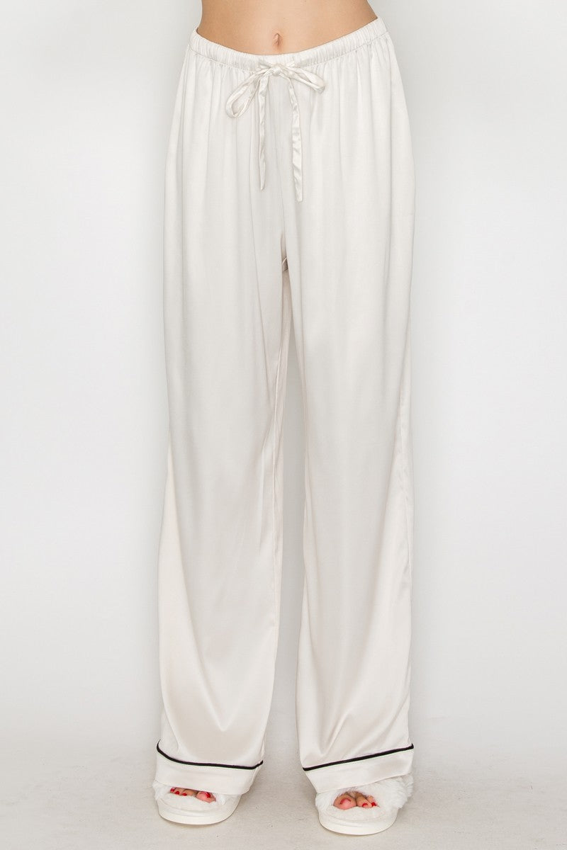 Soft, cream-colored contrast wide leg pajama pants with a drawstring waist and black detailing, perfect for Long Island boutique fashion.