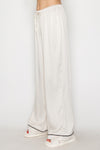 Cream contrast wide leg pajama pants feature a soft, flowing fabric with a drawstring waist, perfect for cozy nights in Long Island boutique fashion.