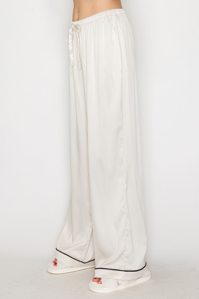 Cream contrast wide leg pajama pants feature a soft, flowing fabric with a drawstring waist, perfect for cozy nights in Long Island boutique fashion.
