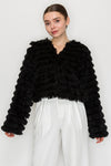 Cropped black faux fur shaggy jacket with textured fringes and wide sleeves, perfect for trendy Long Island boutique fashion.