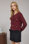 Warm burgundy cardigan featuring gold buttons and textured pockets, embodying cozy style perfect for Long Island boutique fashion.