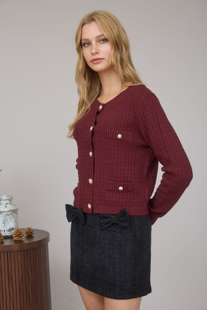 Warm burgundy cardigan featuring gold buttons and textured pockets, embodying cozy style perfect for Long Island boutique fashion.