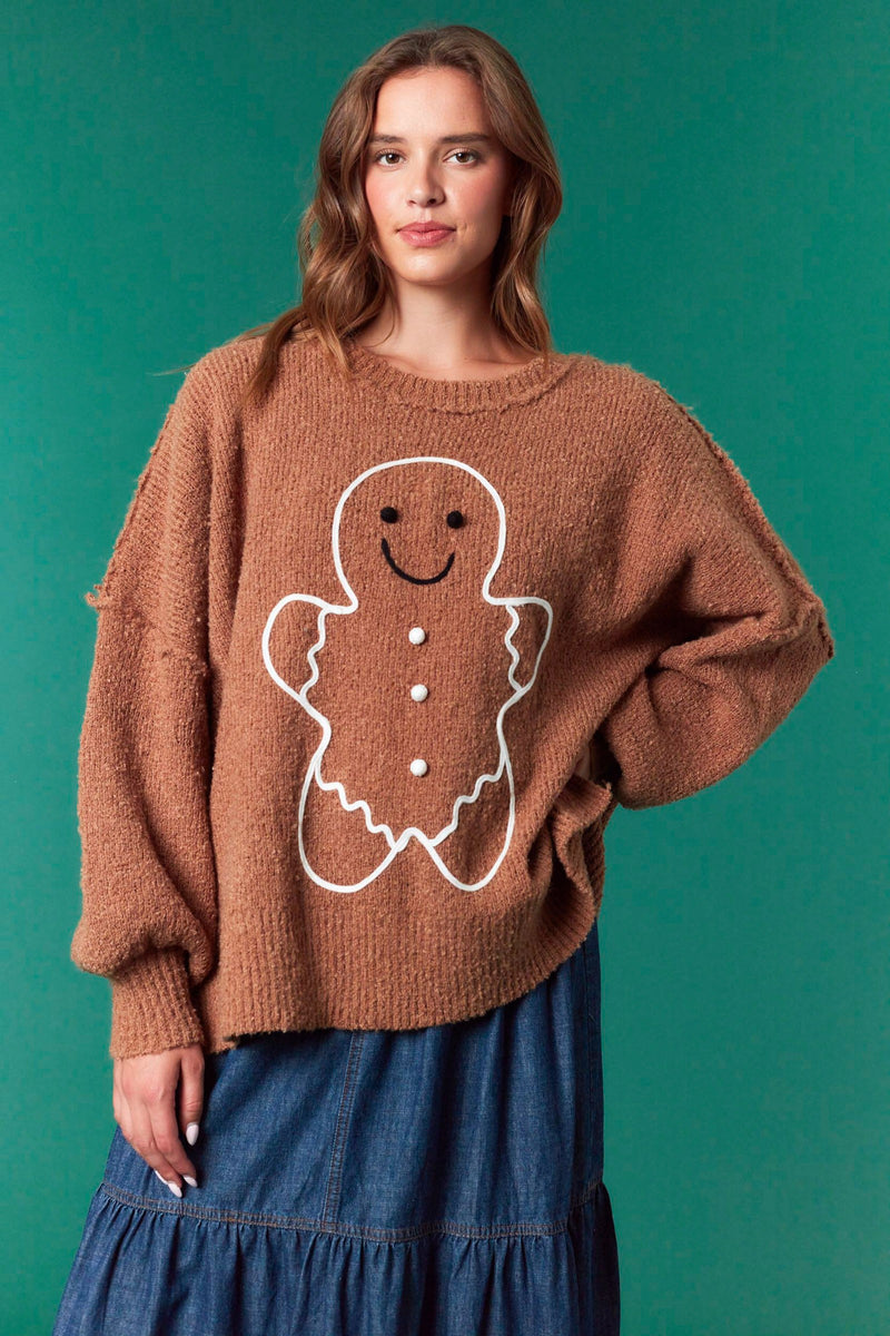 Model wearing Gingerbread Man Oversized Sweater in brown — soft fuzzy knit with large gingerbread graphic, available at TandyWear Boutique in Commack, NY. front view