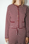 Maroon and white striped outfit with buttons on a plain background