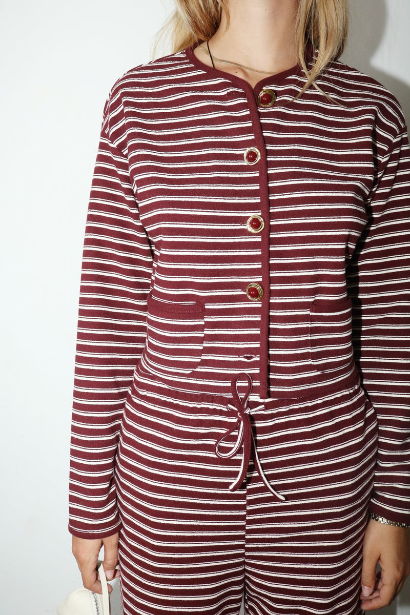 Maroon and white striped outfit with buttons on a plain background