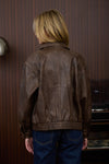 Washed brown faux leather jacket with a collared neck, zip front, and relaxed fit, perfect for Long Island boutique fashion.